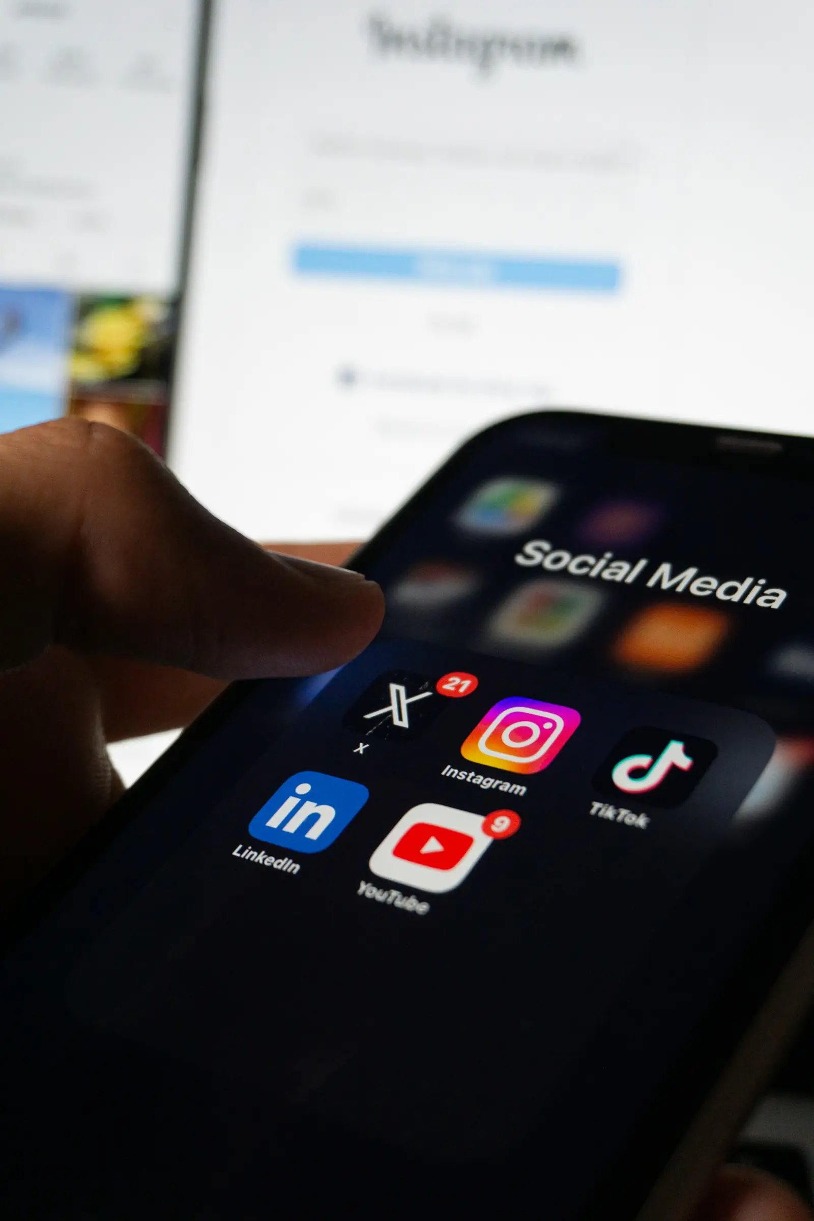 Main tenant un smartphone affichant des applications de réseaux sociaux